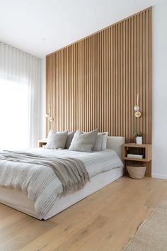 a large bed sitting in the middle of a bedroom next to a wooden headboard