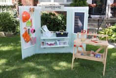 an outdoor booth with various items on display in the grass, including balloons and other decorations