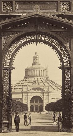 an old black and white photo of people in front of a large building with arches