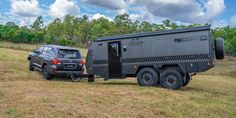 a truck towing a camper in the middle of a field