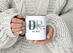 a woman holding a coffee mug with the word dr on it