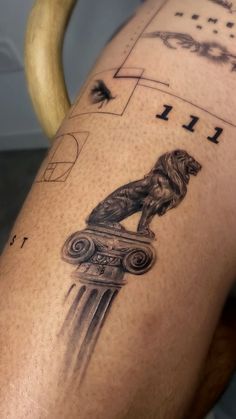 a tattoo on the leg of a person with a lion and column in front of them