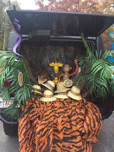 an animal print blanket and hats in the back of a car with decorations on it