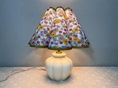 a white lamp sitting on top of a table next to a blue and white wall