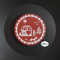 a red and white plate with an image of a carousel on it's side