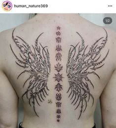 the back of a man with an intricate tattoo design on his upper and lower back