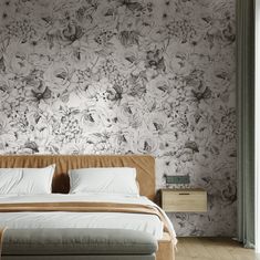 a large bed sitting next to a window in a room with floral wallpaper on the walls