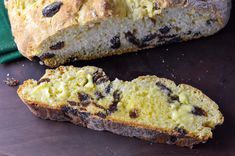 a loaf of bread with raisins and chocolate chips cut in half on a cutting board