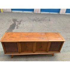 an old wooden tv stand sitting on the sidewalk