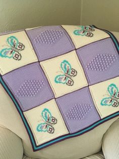 a crocheted butterfly afghan on a chair cushion in the shape of a rectangle