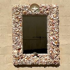 there is a mirror made out of rocks and shells on the side of a building