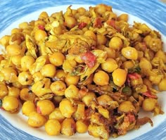 a white plate topped with chickpeas and other food on top of a wooden table