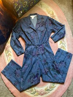 Amazing! Denim long sleeve floral print jumpsuit Buttons down chest of suit Elastic waistline Cotton material Pockets Shoulder pads Amazing condition with one small flaw the latch for the eyelid clasp at front waist has broke No biggie really but needed to be noted Other then that seems barely worn Fits a xsmall/small Measurements are approximate and taken flat so please double bust waist and hips for more accurate sizing Bust: 18.5 in Waist: 12.5 in stretched taunt to 14 in Hips: 16 in Rise: 30 Womens Denim Jumpsuit, Vintage Floral Skirt, Cotton Candy Colors, 80s Floral, Floral Print Jumpsuit, Print Denim, Print Jumpsuit, Vintage Floral Print, Printed Jumpsuit