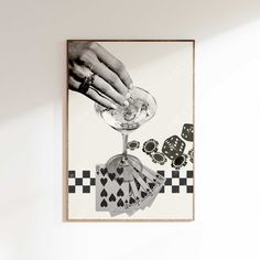 a hand holding a wine glass with playing cards on it