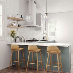 three wooden stools sit in front of an island