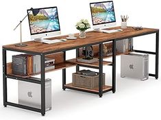 two computer monitors sitting on top of a wooden desk next to a keyboard and mouse