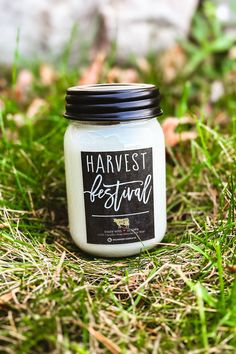 a jar of harvest festival candles sitting in the grass