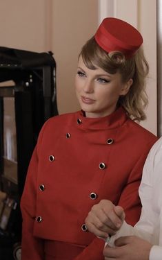 a woman in a red hat is standing next to another woman