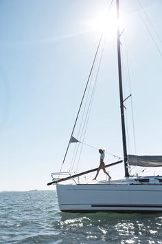 a person walking on the deck of a sailboat