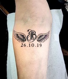 a person with a tattoo on their leg that has wings and the number between them