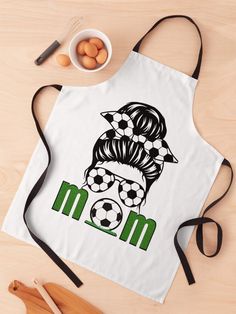 an apron with a woman's face and soccer ball on it, next to eggs