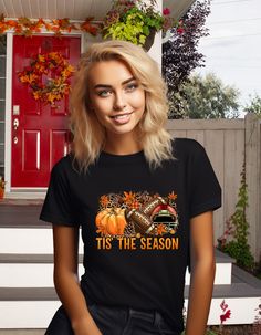 Get ready for football, pumpkin season, and the fall weather with the Tis The Season Autumn Graphic T-Shirt! This cute and bold t-shirt is perfect for football watch parties and pairs perfectly with your favorite jeans and sneakers. Made with Gilden softstyle fabric, it's fade resistant and preshrunk. Size up for an oversized look. Fall Sports Fan Tops With Letter Print, Sports Fan Tops With Letter Print For Fall, Sports Fan Letter Print Tops For Fall, Black T-shirt For Fall Game Day, Black T-shirt For Game Day In Fall, Fall Fan Apparel T-shirt With Graphic Print, Fall Crew Neck T-shirt For Fan Gear, Fall Graphic Tee Fan Merchandise Tops, Fall Fan Gear T-shirt With Crew Neck