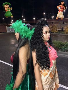 two women dressed in costumes standing next to each other on the street at night time