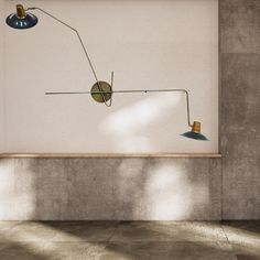 a wall mounted lamp on the side of a white wall in an empty room with concrete flooring