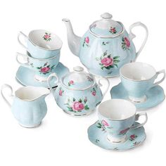 a blue tea set with pink roses on the side and four cups, one filled with saucers