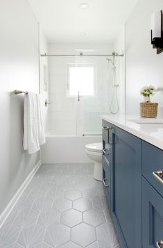 a white and blue bathroom with hexagonal tiles