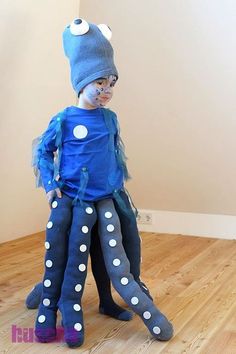 a young child dressed in blue and white polka dot clothing with an octopus costume on