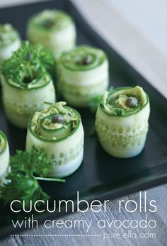 cucumber rolls are arranged on a black plate