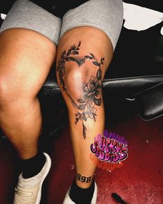 a woman's legs with tattoos and flowers on them