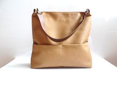 "Vegan leather casual hobo shoulder bag in honey cognac brown with two outside slip pockets and real leather handle. * Exterior - High quality supple vegan leather in cognac honey toffee camel brown. - Two outside exterior pockets *Interior - Natural cotton in light sandy beige and white polka dot print - Two inside interior pockets * Real leather strap from high quality Italian genuine leather in gorgeous dark chocolate brown color. Reinforced with antique toned brass rivets. Detachable. * The Honey Toffee, Cognac Bag, Chocolate Brown Colour, Dark Chocolate Brown, Brown Bag, Honey Brown, Leather Hobo Bag, Brown Bags, Leather Hobo