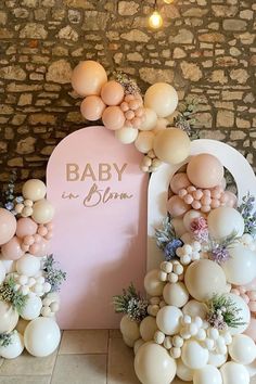 balloons and flowers decorate the entrance to a baby shower