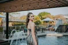 a woman standing in front of a fountain