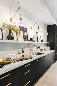 a kitchen with marble counter tops and gold pulls on the cabinets, along with brass accents