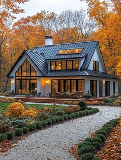 a house in the fall with lots of leaves on the ground and trees around it