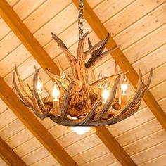 a chandelier with antlers hanging from it's ceiling in a cabin