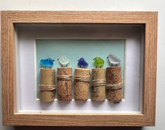 three corks are wrapped in twine and tied together with birds on each one