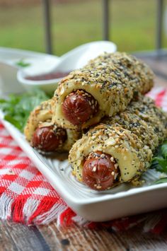 two hot dogs wrapped in sesame seeds on a plate