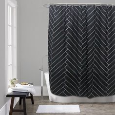 a bathroom with a bathtub, rug and shower curtain that has an arrow pattern on it