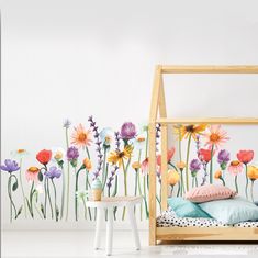 a bedroom with flowers painted on the wall and a bed in front of it,