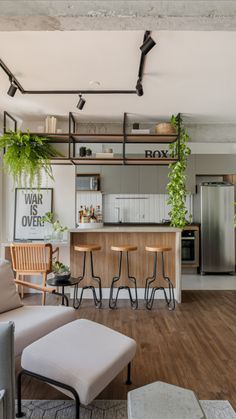 an open concept kitchen and living room with wood flooring, white walls and ceiling