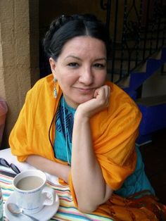 a woman sitting at a table with a cup and saucer