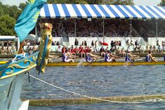 people are rowing on the water in front of a large crowd at a sporting event