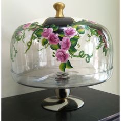 a glass covered dish with flowers painted on it