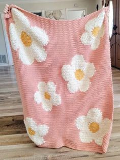 a crocheted blanket with white flowers on it