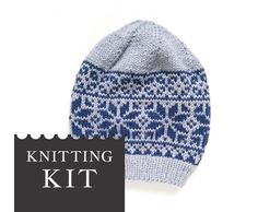 a knitted hat with blue and white designs on it, next to the knitting kit