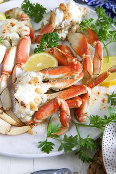 crab legs with lemon wedges and parsley on a plate